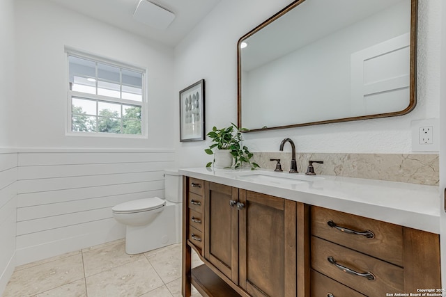 bathroom with toilet, tile patterned flooring, and vanity