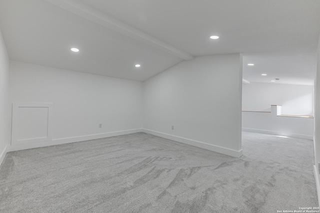 interior space featuring light carpet and lofted ceiling with beams