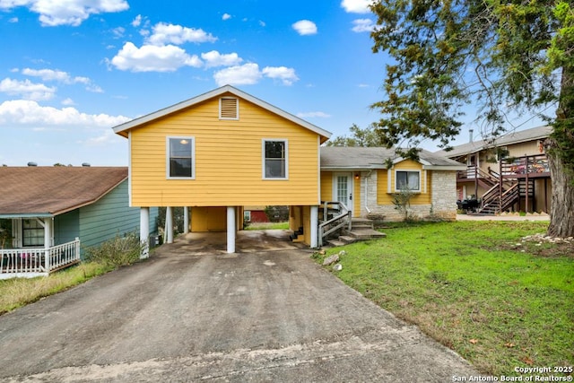 tri-level home with a front lawn and a carport