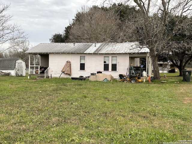 back of house with a yard and a shed