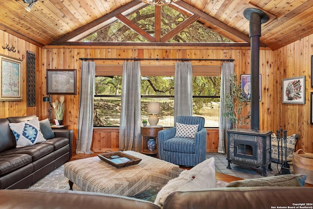 living room featuring wood ceiling, a wood stove, and wooden walls