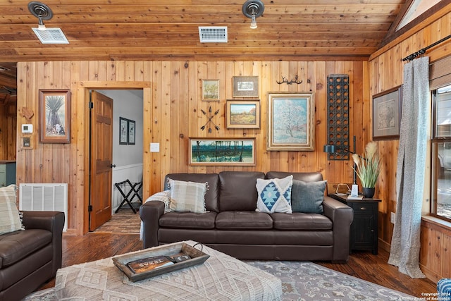 living area featuring vaulted ceiling, wood finished floors, and visible vents