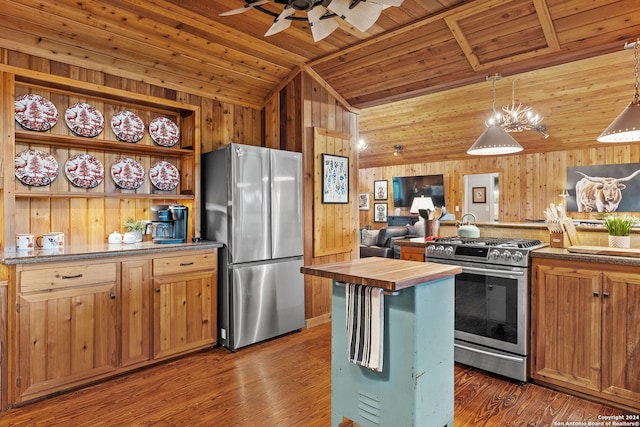 kitchen with wooden walls, wood ceiling, wood counters, appliances with stainless steel finishes, and wood finished floors