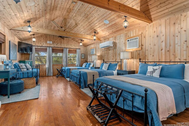 bedroom featuring an AC wall unit, a wall mounted air conditioner, wood-type flooring, and lofted ceiling with beams