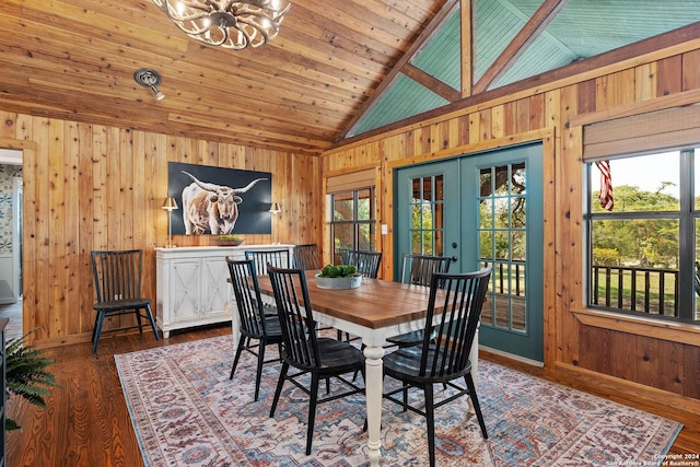 dining space featuring french doors, an inviting chandelier, wood ceiling, wooden walls, and wood finished floors