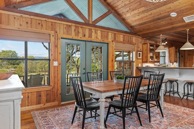 dining space featuring french doors, wood walls, wood finished floors, and visible vents