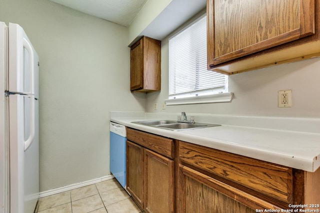 kitchen with sink, white appliances, and light tile patterned floors