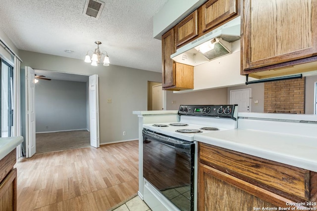 kitchen with a textured ceiling, ceiling fan with notable chandelier, light hardwood / wood-style floors, and white electric stove