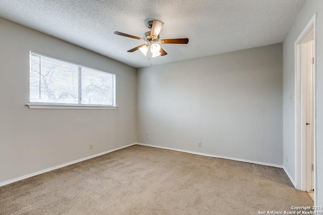 unfurnished room featuring ceiling fan, light colored carpet, and a textured ceiling