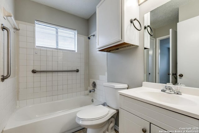 full bathroom with toilet, vanity, tiled shower / bath combo, and a textured ceiling