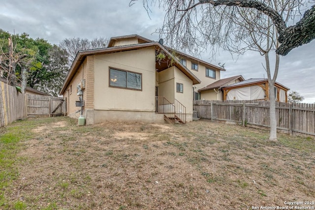 rear view of house featuring a yard