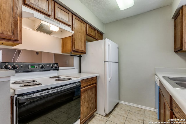 kitchen with white fridge, light tile patterned floors, range with electric cooktop, a textured ceiling, and sink