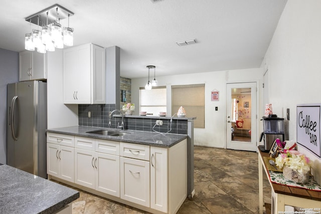 kitchen with stainless steel fridge with ice dispenser, white cabinetry, pendant lighting, and sink