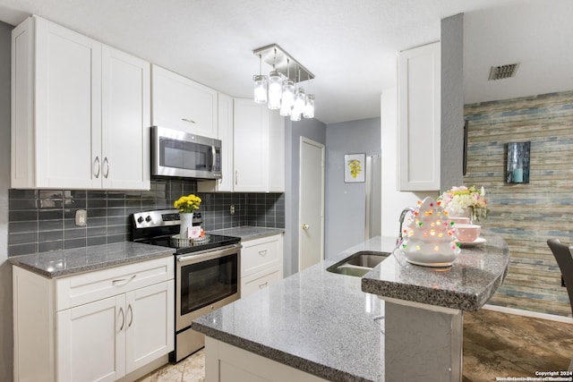 kitchen with backsplash, a center island, sink, stainless steel appliances, and white cabinets