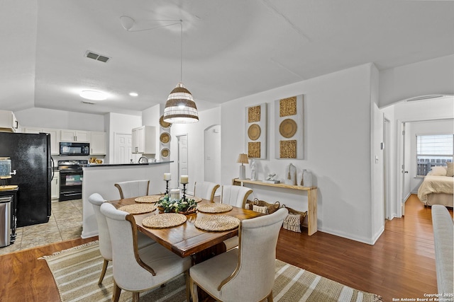 dining room featuring vaulted ceiling and hardwood / wood-style flooring