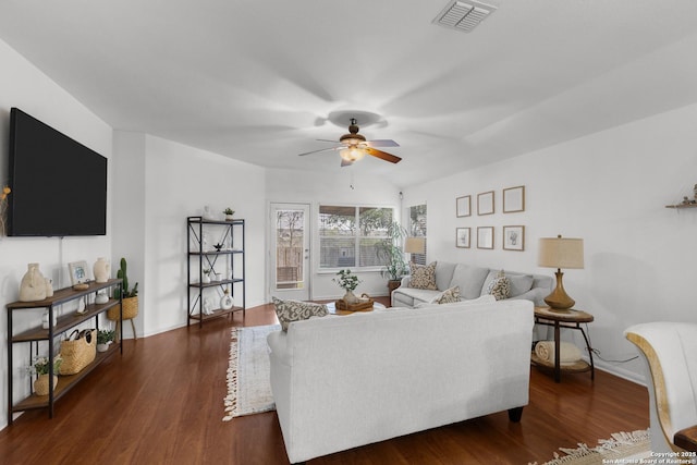 living room with ceiling fan and dark hardwood / wood-style flooring