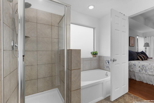 bathroom with plus walk in shower, a wealth of natural light, and wood-type flooring