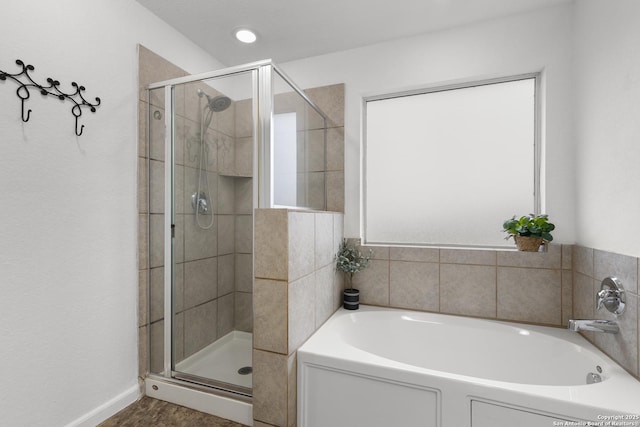 bathroom with a wealth of natural light and independent shower and bath