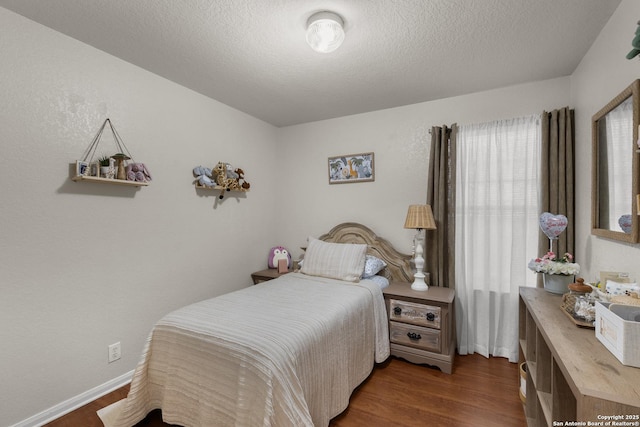 bedroom featuring dark wood-type flooring and a textured ceiling