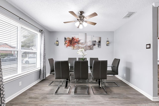 dining space featuring ceiling fan, a textured ceiling, and hardwood / wood-style floors