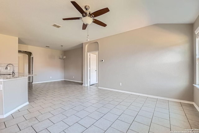 unfurnished living room with ceiling fan with notable chandelier, sink, and light tile patterned floors