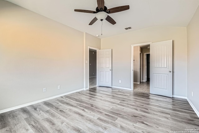 unfurnished bedroom with ceiling fan, ensuite bathroom, light hardwood / wood-style flooring, and lofted ceiling