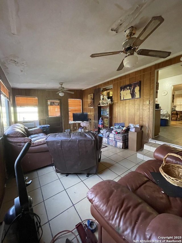 tiled living room with ceiling fan and wooden walls