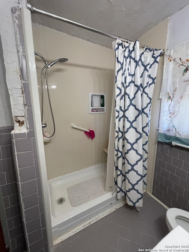 bathroom with a textured ceiling, a shower with shower curtain, tile patterned floors, and toilet