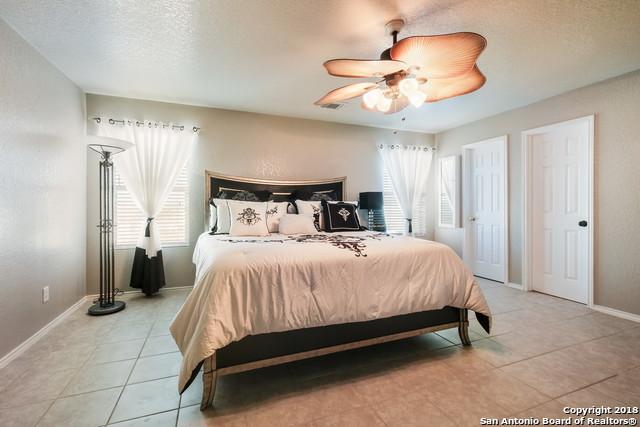 bedroom with ceiling fan, a textured ceiling, and light tile patterned flooring