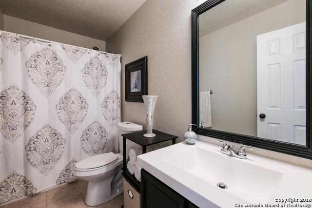 bathroom with toilet, vanity, tile patterned flooring, and a textured ceiling