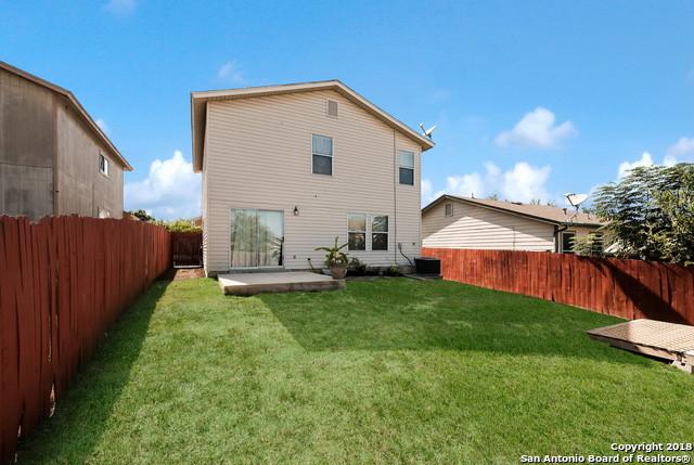 rear view of property featuring cooling unit, a yard, and a patio