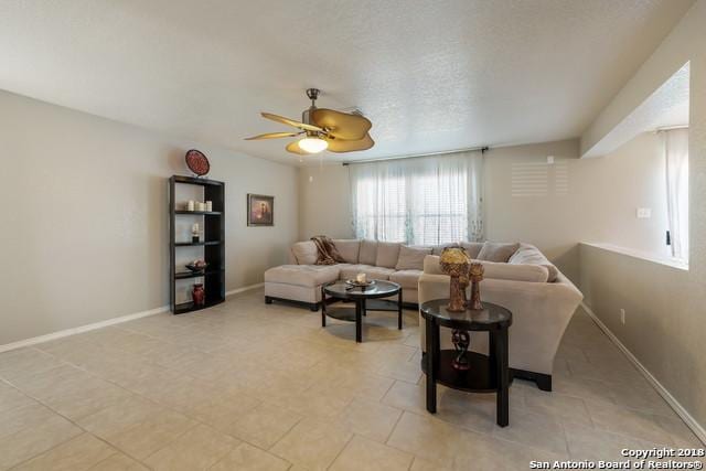 living room with a textured ceiling and ceiling fan