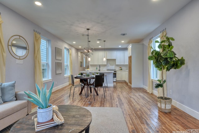 dining space featuring a wealth of natural light, light hardwood / wood-style flooring, and a chandelier