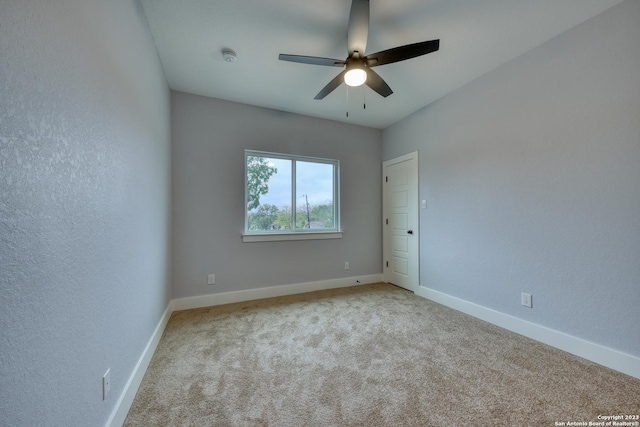 carpeted spare room with ceiling fan