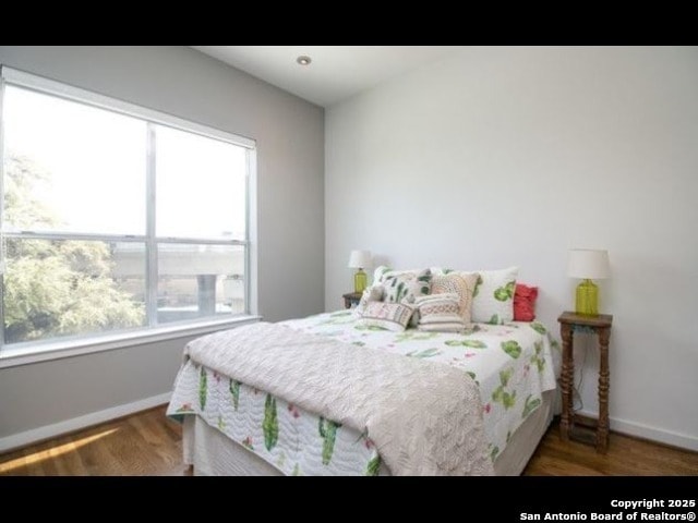 bedroom with dark hardwood / wood-style flooring