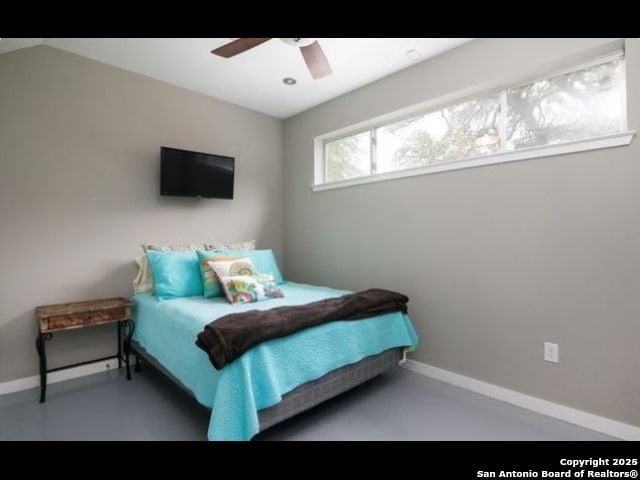 bedroom with ceiling fan and concrete flooring