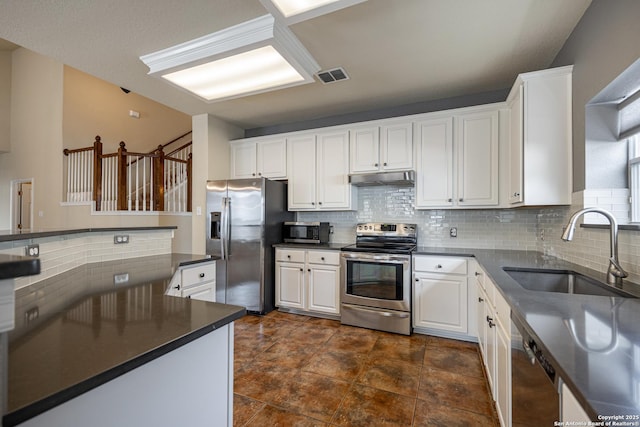 kitchen featuring tasteful backsplash, stainless steel appliances, sink, and white cabinets