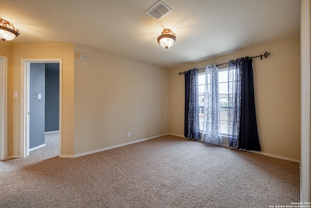 spare room featuring carpet floors and a textured ceiling