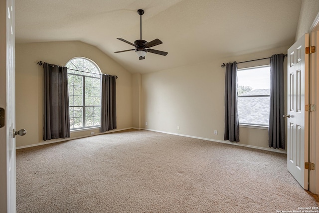 carpeted empty room with a textured ceiling, vaulted ceiling, and ceiling fan