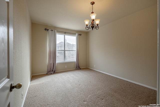 spare room with a chandelier and carpet