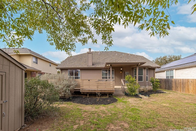 back of house with a deck and a lawn