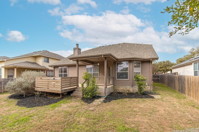 rear view of property featuring a wooden deck and a yard