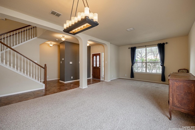 foyer entrance featuring dark colored carpet