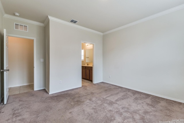 unfurnished bedroom featuring light carpet, ornamental molding, and ensuite bath