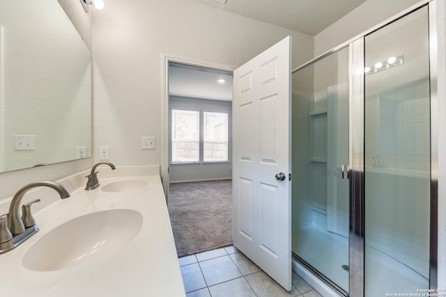 bathroom featuring tile patterned floors, a shower with door, and sink