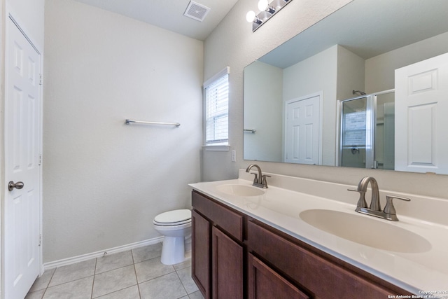 bathroom with toilet, tile patterned flooring, a shower with door, and vanity