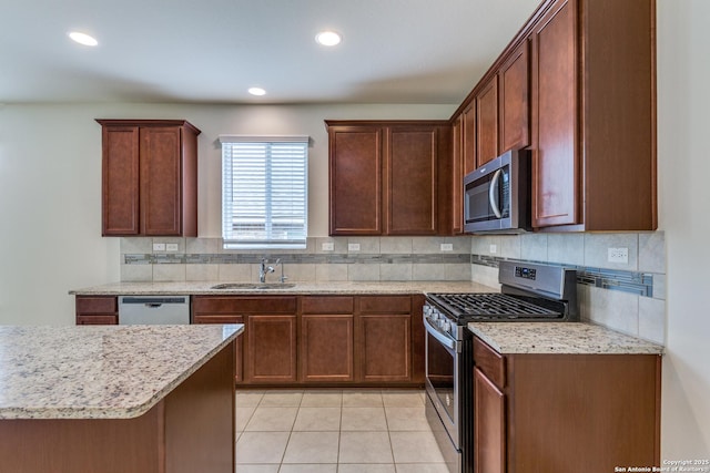 kitchen with light tile patterned floors, sink, appliances with stainless steel finishes, and tasteful backsplash