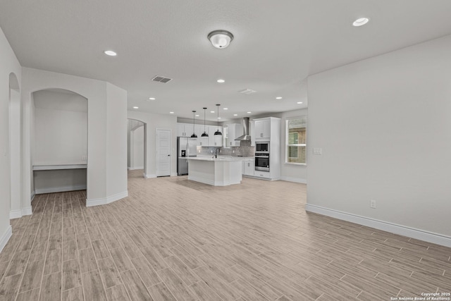 unfurnished living room with sink and light hardwood / wood-style floors