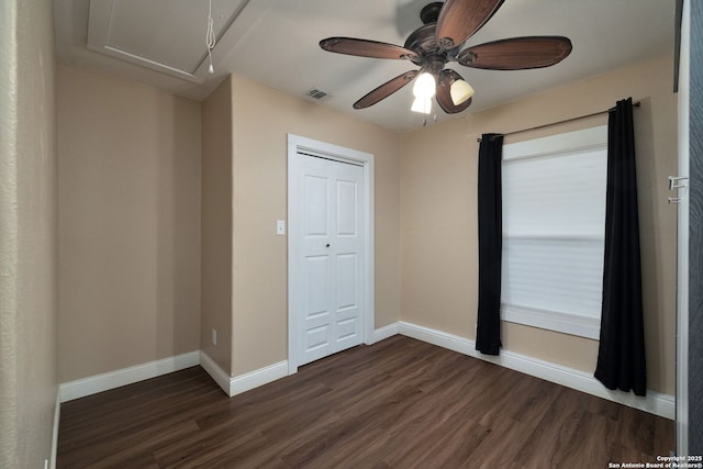 unfurnished bedroom featuring ceiling fan, a closet, and dark hardwood / wood-style flooring