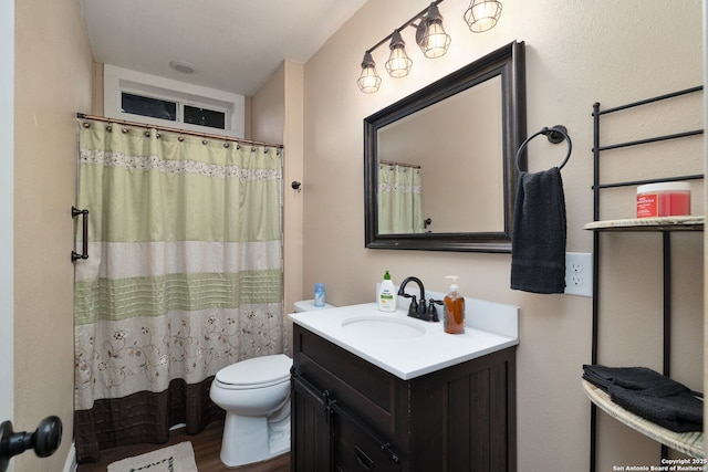 bathroom with toilet, vanity, curtained shower, and hardwood / wood-style floors